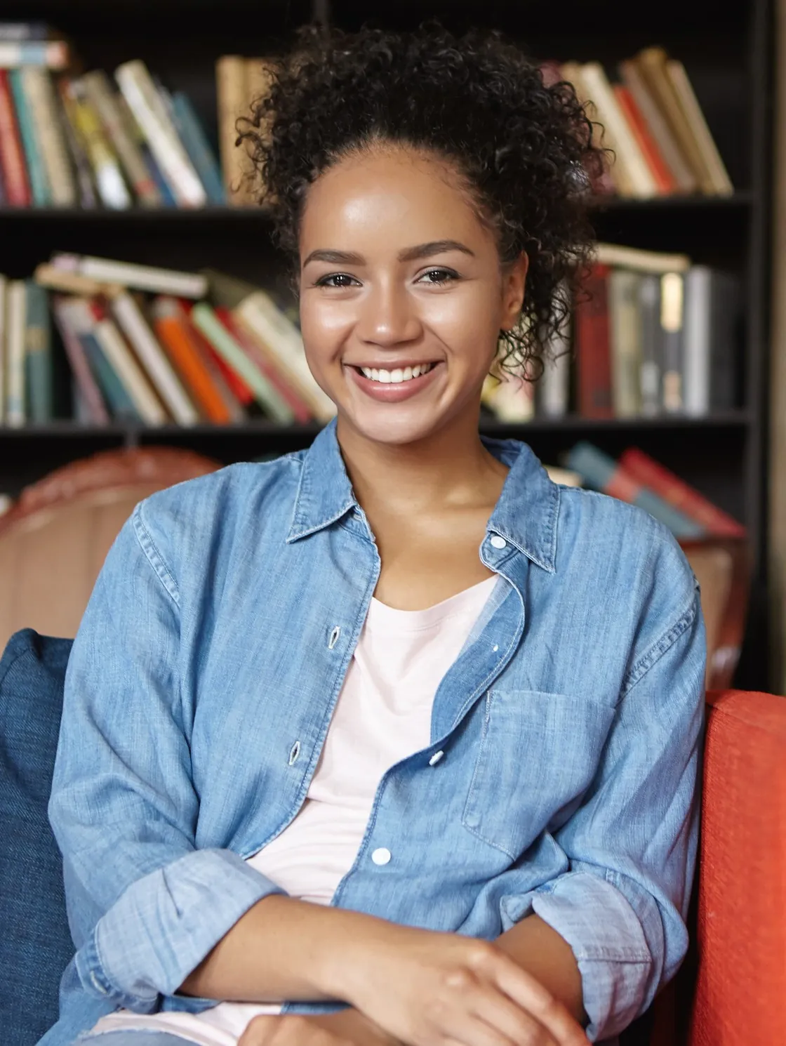 Estudante brasileira sorrindo em uma biblioteca, participante do Summer Job